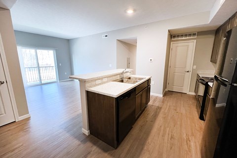 an empty kitchen and living room with wood flooring and a large window  at Brookfield Village Apartments, Ohio