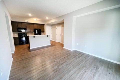 an empty living room and kitchen with wood flooring  at Brookfield Village Apartments, Grove City