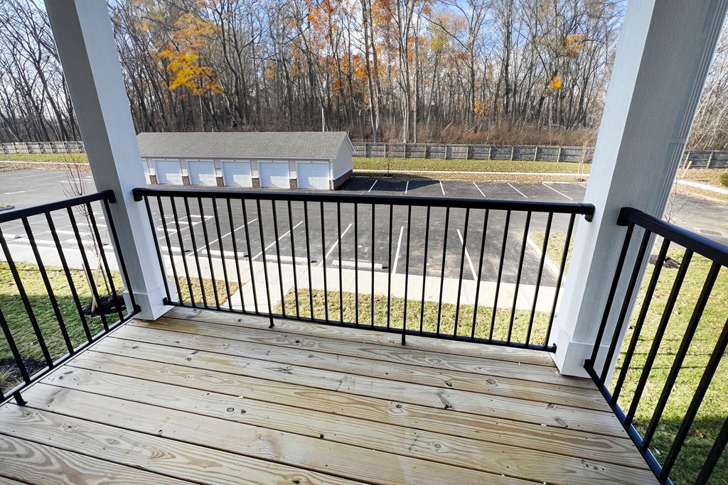 a balcony with a view of a parking lot and trees  at Brookfield Village Apartments, Grove City