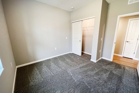 a bedroom with a carpeted floor and a closet  at Brookfield Village Apartments, Grove City