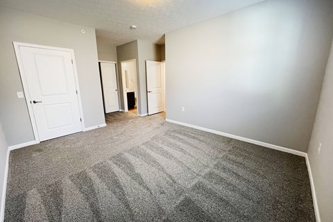 an empty living room with carpet and white doors  at Brookfield Village Apartments, Grove City, OH, 43123