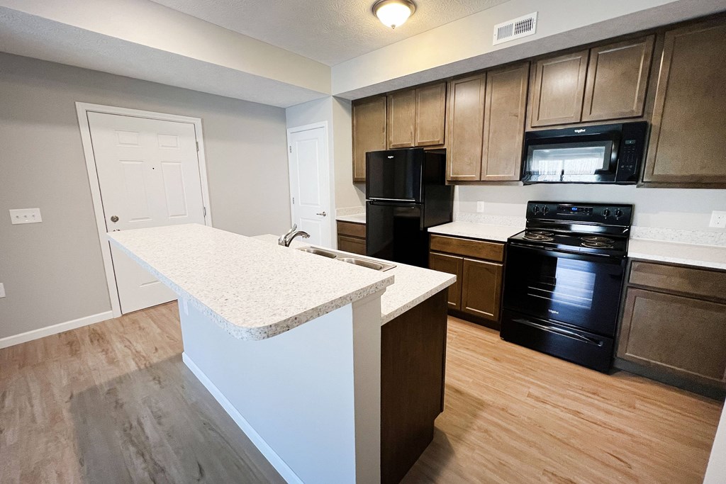 an empty kitchen with an island in the middle of it