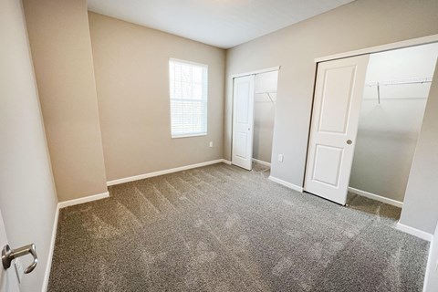 an empty bedroom with a closet and a door to the bathroom  at Brookfield Village Apartments, Grove City