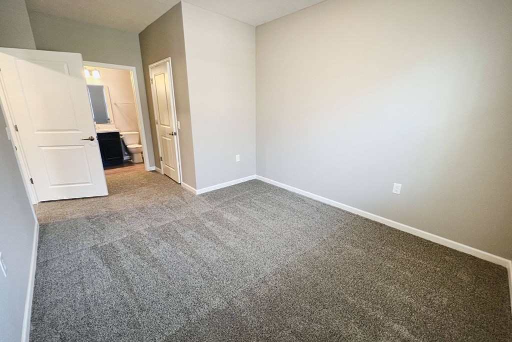 an empty living room with carpeting and white walls  at Brookfield Village Apartments, Ohio