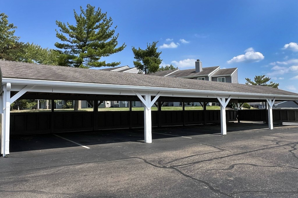 a covered parking lot with a building in the background at Deercross Apartments, Cincinnati