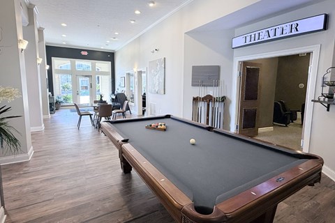 A pool table in a room with a sign that says "THEATER".