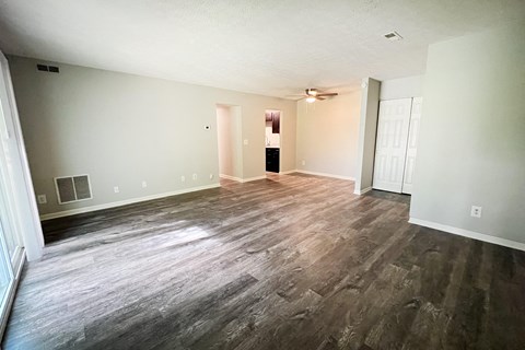 the living room and dining room of an empty home with wood flooring at Crown Crossing Apartments, Amelia, Ohio 45102
