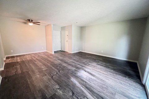 an empty living room with wood floors and a ceiling fan at Crown Crossing Apartments, Amelia, OH