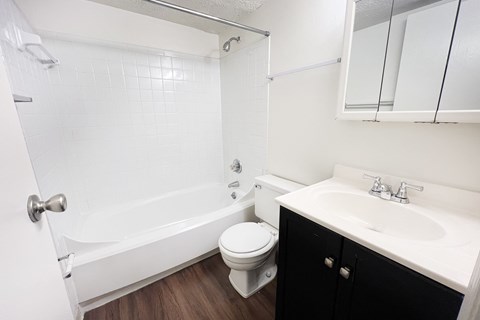 A white bathroom with a toilet, sink, and bathtub at Crown Crossing Apartments, Amelia, Ohio
