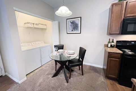 A small dining area with a glass table and a black chair.