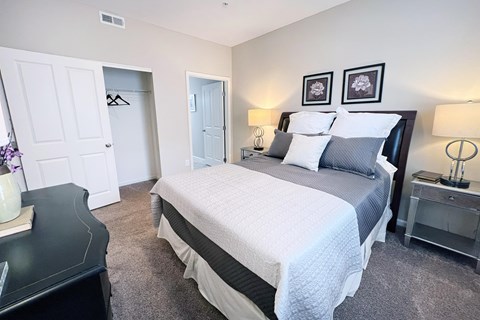 A bedroom with a large bed and two nightstands.