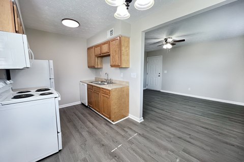 A kitchen with a white stove top oven and a white refrigerator.