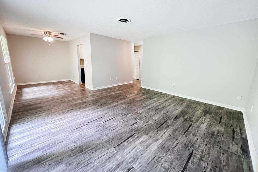 A room with wooden flooring and white walls.