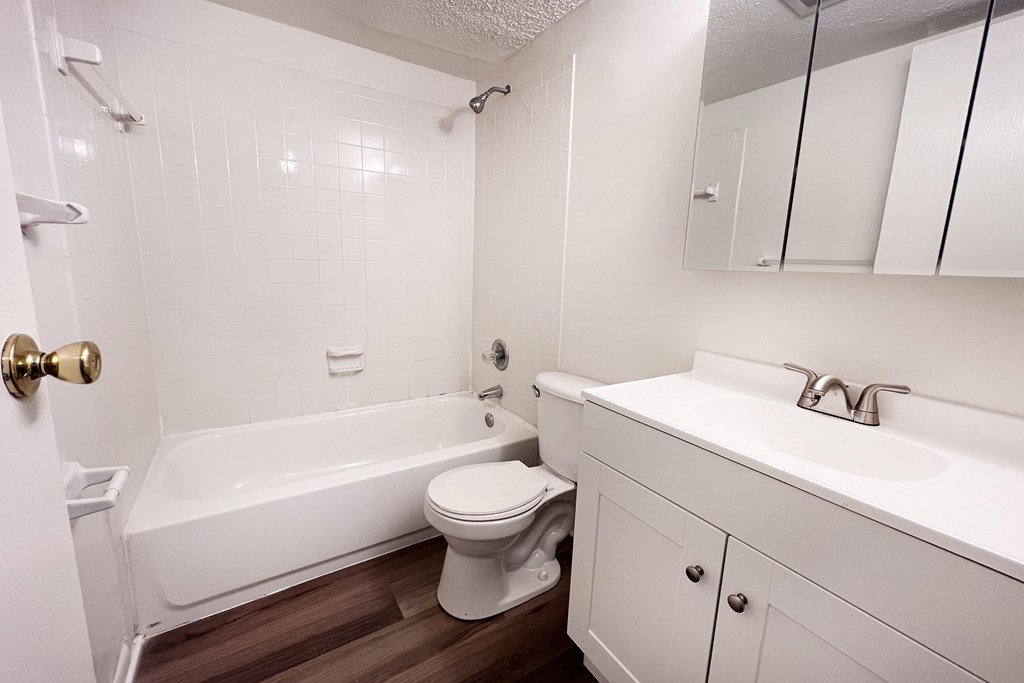 A white bathroom with a toilet, sink, and bathtub.