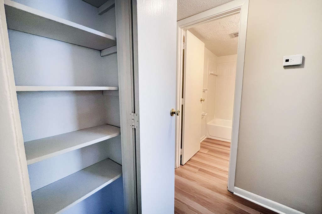 A white refrigerator with four shelves is open.