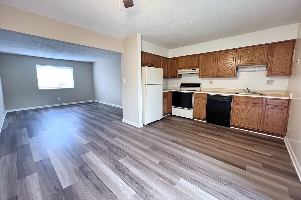 A kitchen with wooden cabinets and a white refrigerator.
