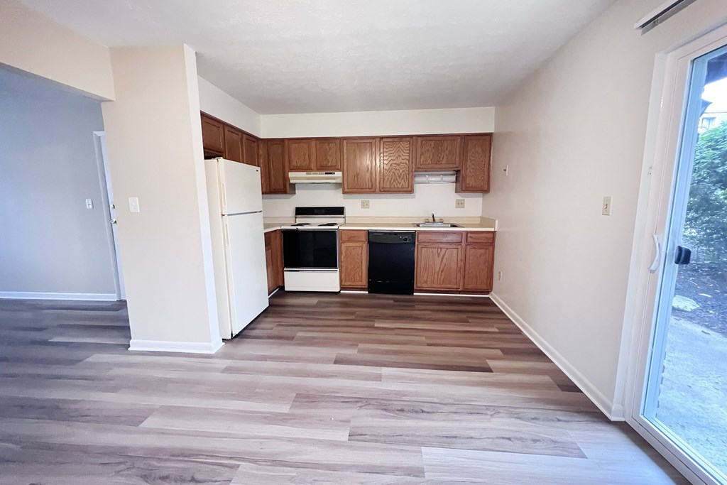 A kitchen with wooden cabinets and a white refrigerator.