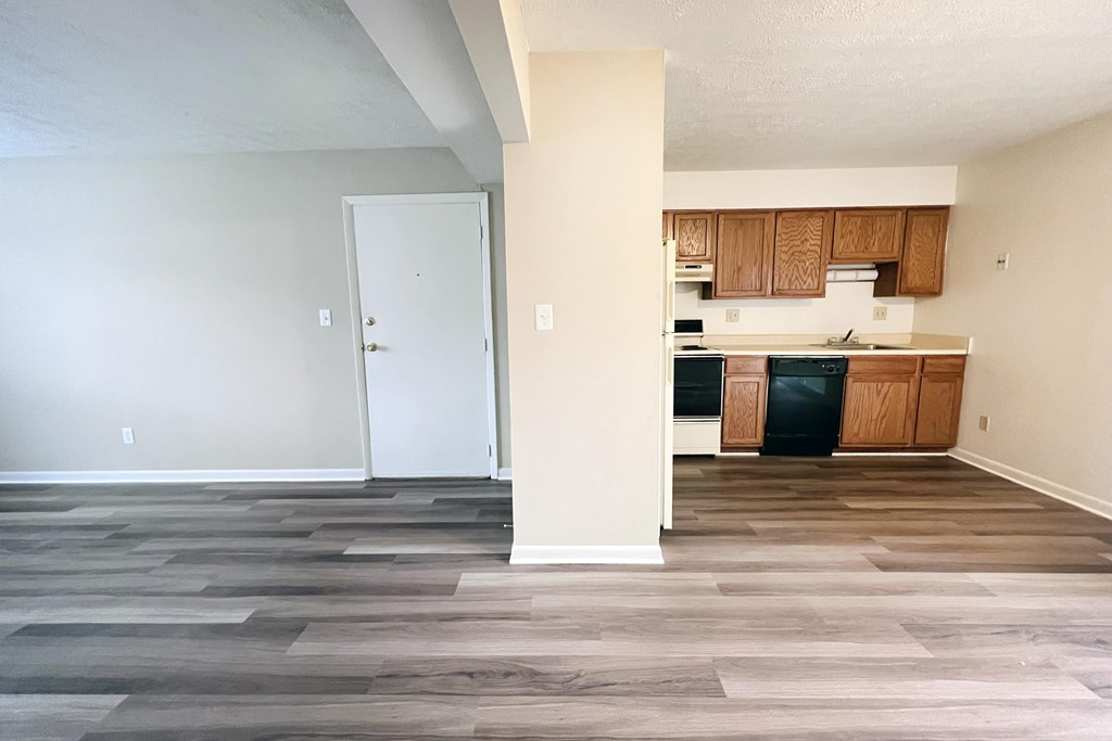 A kitchen with wooden cabinets and a white door.