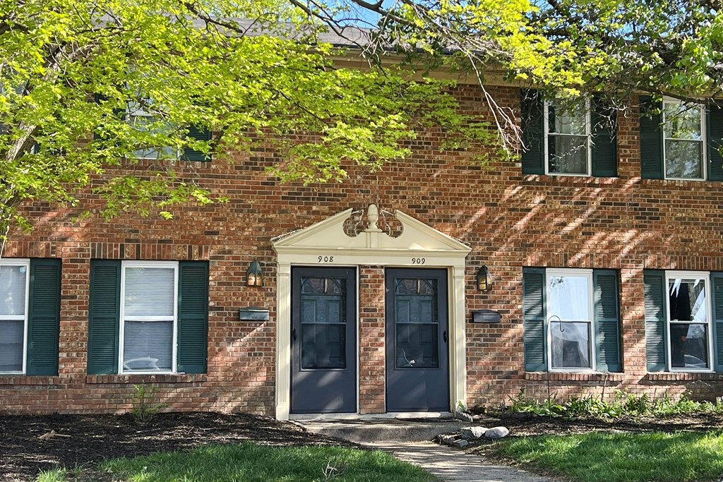 a brick building with blue doors and green shutters at Revere Village Apartments, Centerville, 45458