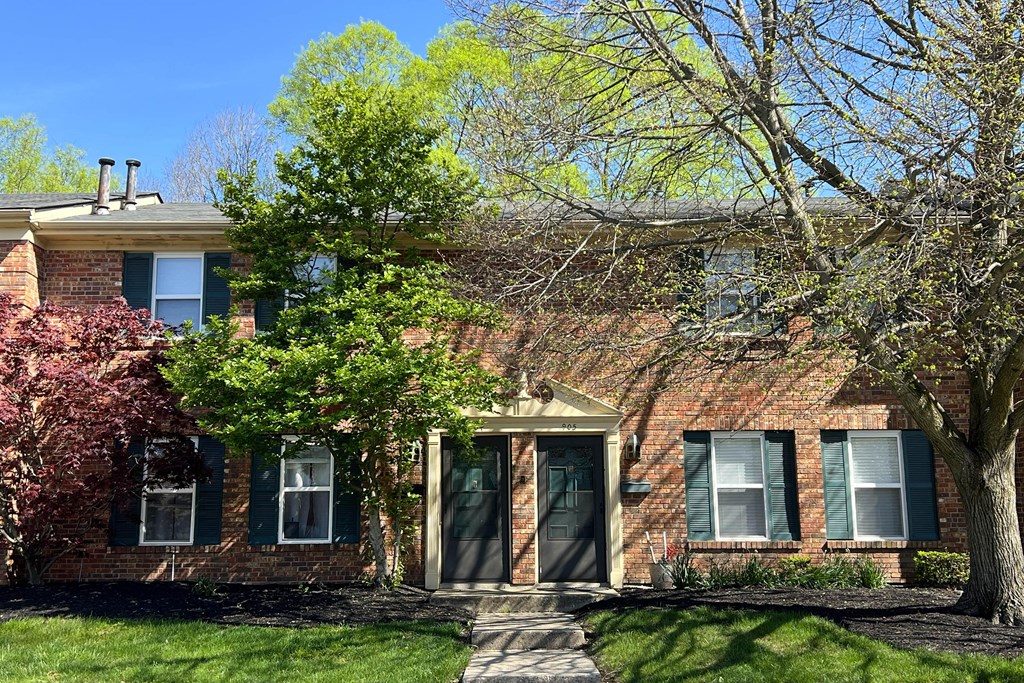 a brick house with a tree in front of itat Revere Village Apartments, Centerville, Ohio