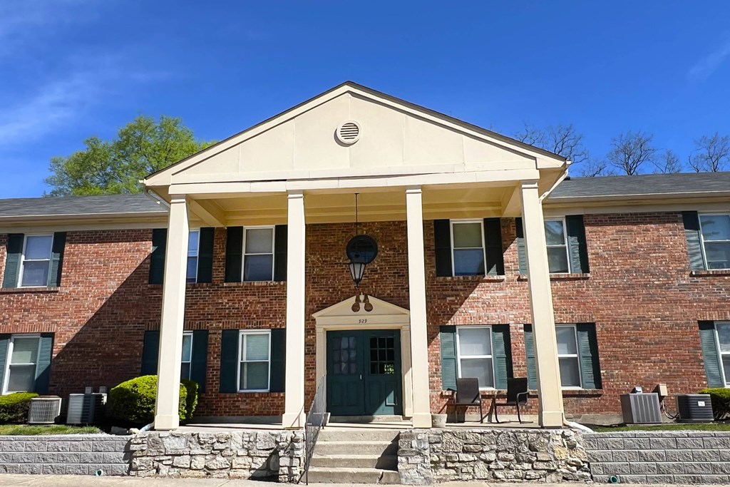 the front of a brick building with columns and a porchat Revere Village Apartments, Centerville, Ohio