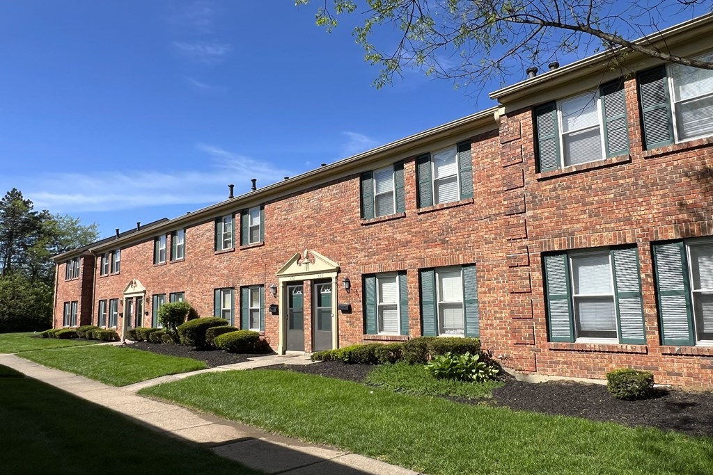 a brick apartment building with a sidewalk and grassat Revere Village Apartments, Centerville, 45458