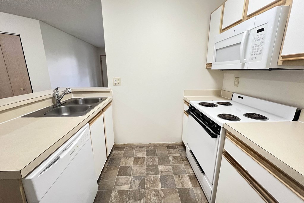 a kitchen with white appliances and a sink and a stove at Eagle Crest Apartments, Galloway, Ohio