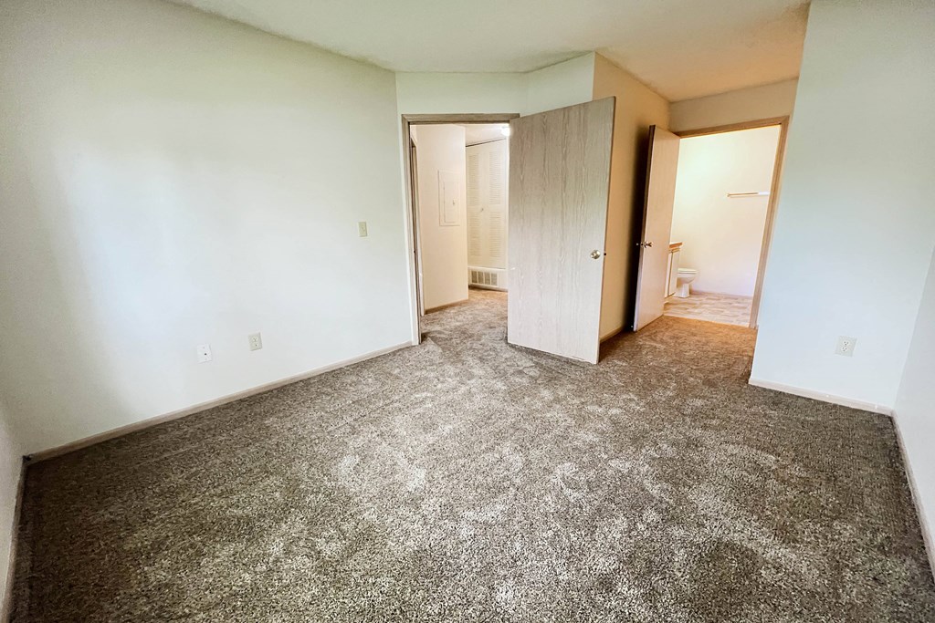 an empty room with a carpeted floor and white walls at Eagle Crest Apartments, Ohio