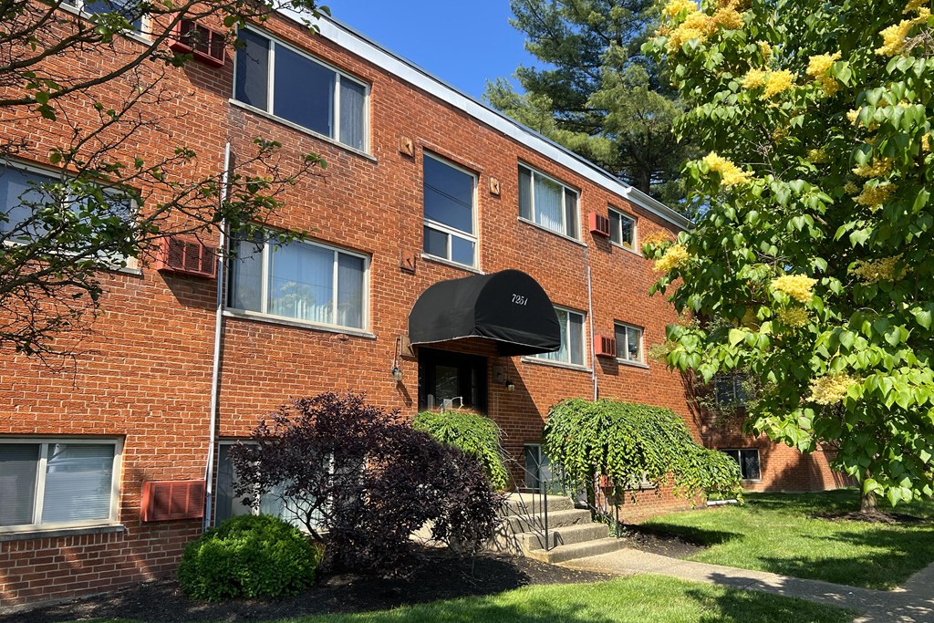 a brick apartment building with a black awning