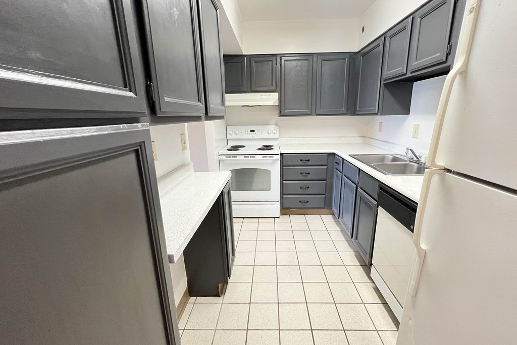 an empty kitchen with black cabinets and white appliances at Indian Lookout Apartments, Cincinnati, OH, 45238