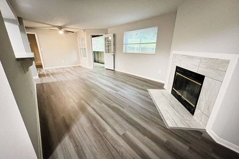 an empty living room with a fireplace and wooden floors at The Vinings Apartments, Cincinnati, Ohio