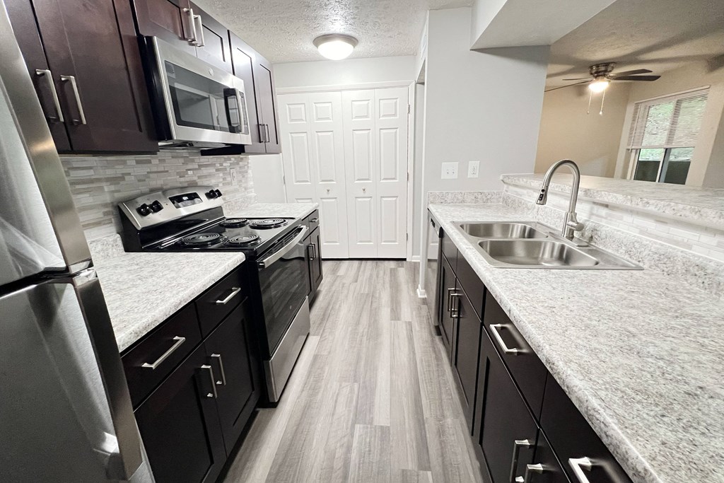 a kitchen with granite counter tops and stainless steel appliances at The Vinings Apartments, Cincinnati, Ohio