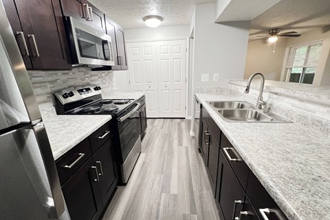 a kitchen with granite counter tops and stainless steel appliances at The Vinings Apartments, Cincinnati, Ohio