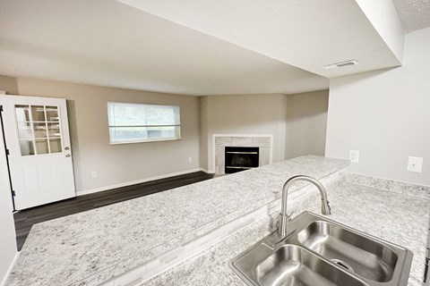 an empty kitchen with a sink and a fireplace at The Vinings Apartments, Cincinnati