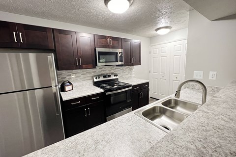 a kitchen with stainless steel appliances and granite counter tops at The Vinings Apartments, Cincinnati, OH, 45245
