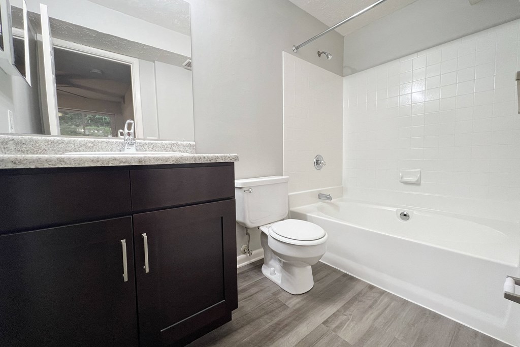 a bathroom with a toilet and a tub and a sink at The Vinings Apartments, Cincinnati, 45245