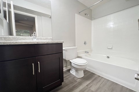 a bathroom with a toilet and a tub and a sink at The Vinings Apartments, Cincinnati, 45245