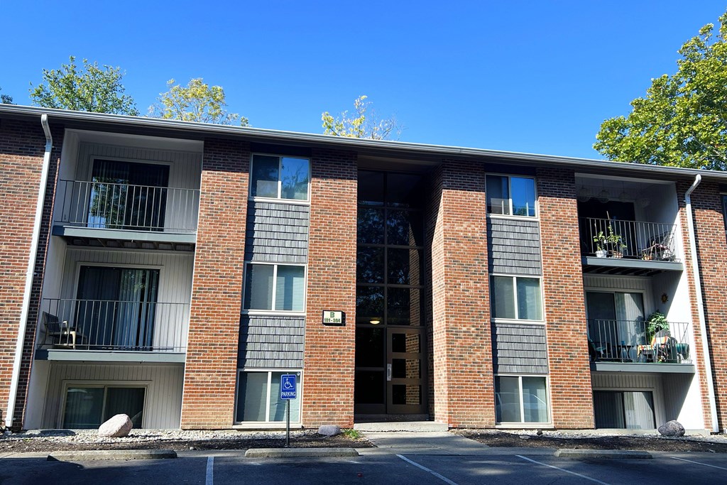 A red brick building with a blue sign on the ground.