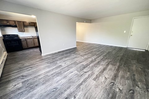 an empty living room with vinyl flooring and a kitchen at Crown Court Apartments, Kentucky, 41042