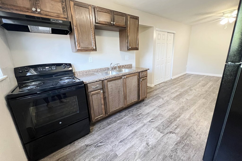 a kitchen with wooden cabinets and a black stove and refrigerator