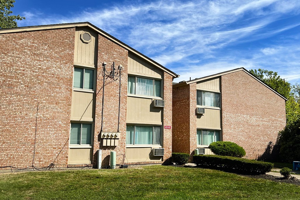 A brick building with a green lawn in front.