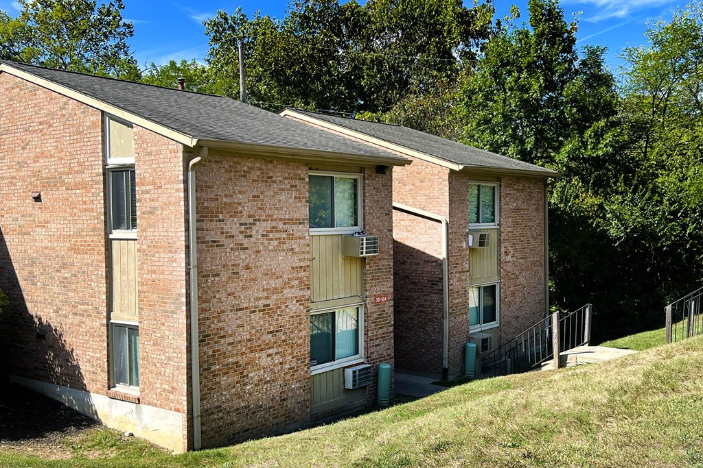 A brick building with a green lawn in front.