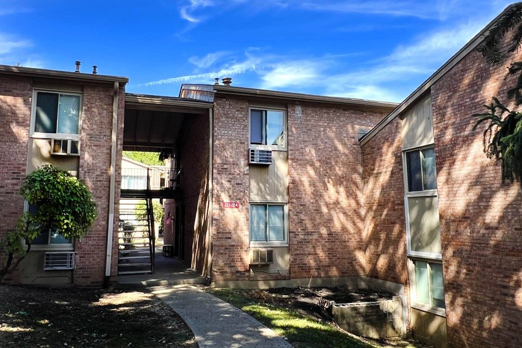 A red brick building with a green plant in front.