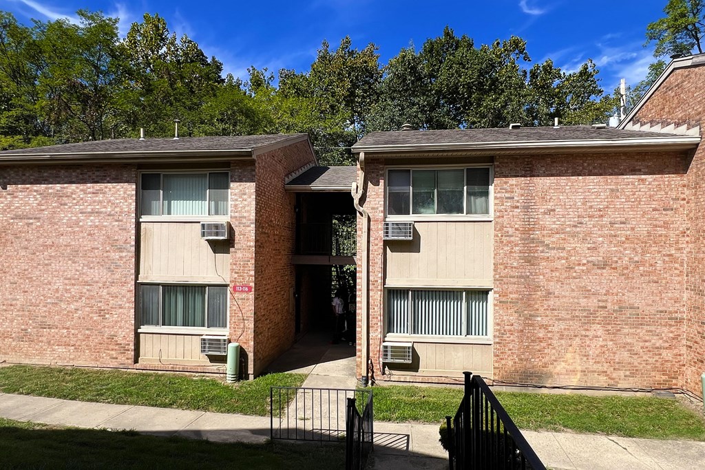 A red brick building with a black gate in front.