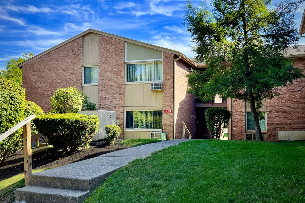 A red brick building with a green lawn in front.