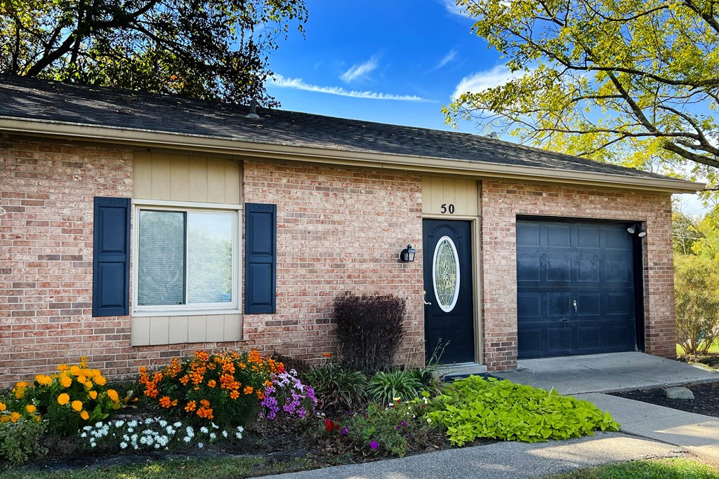 A house with a black door and a window with black shutters.