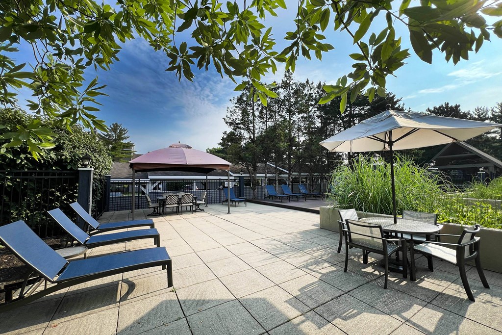 a patio with tables and chairs and umbrellas at Deercross Apartments, Cincinnati, Ohio
