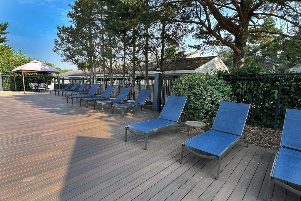 a row of blue lounge chairs on a wooden deck at Deercross Apartments, Ohio, 45236