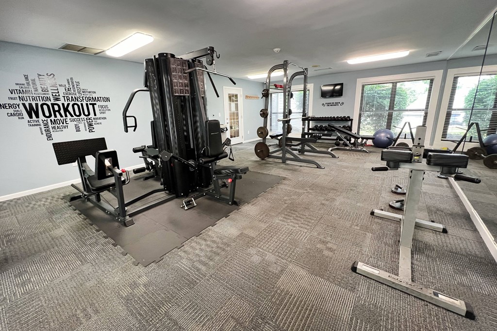 a gym with weights and other equipment in a building with windows at Deercross Apartments, Cincinnati, 45236