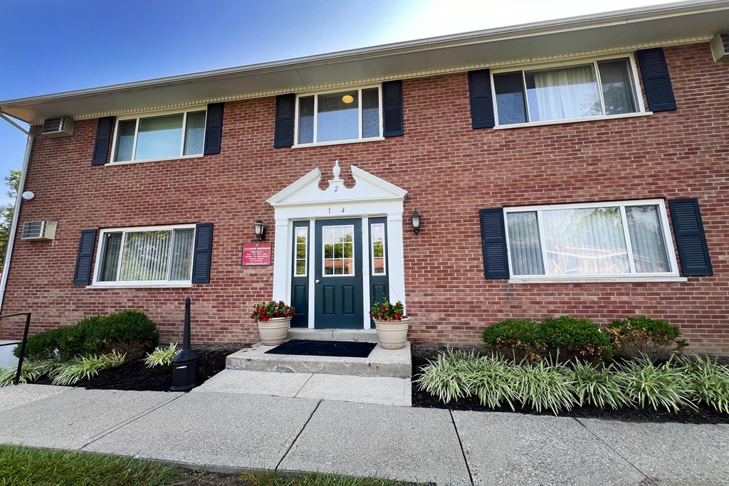the front of a brick house with a blue door at Sharondale Woods Apartments, Cincinnati